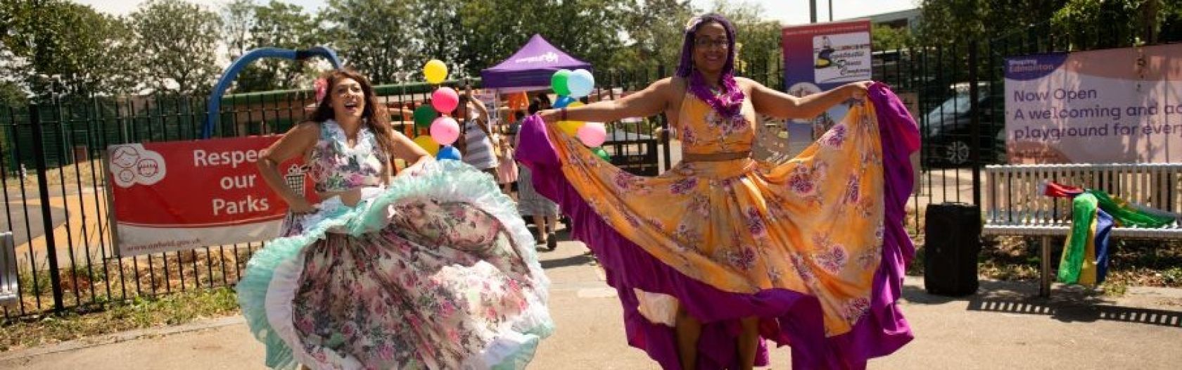 Two dancers  in brightly coloured dresses outside Florence Hayes