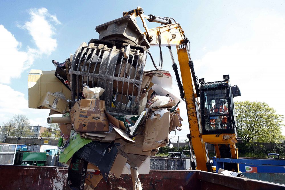A mechanical grabber carrying recycled cardboard. 