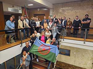 People standing on a staircase holding GRT flag