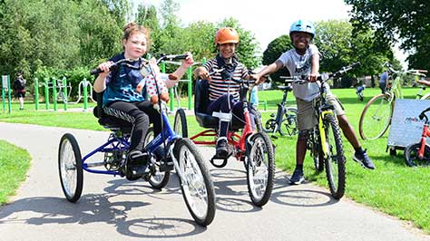 3 children on bikes in a park