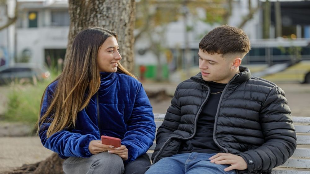 Girl and boy sitting on a bench 