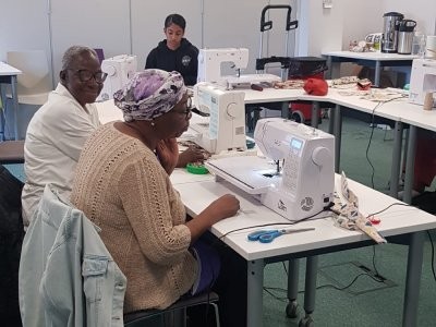 Grace at a sewing machine at a workshop