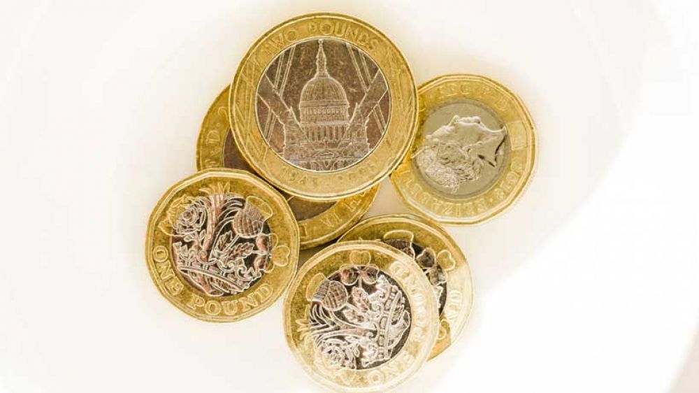 A white bowl of one pound and two pound coins