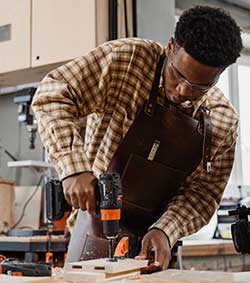 Teenage boy drilling in a workshop