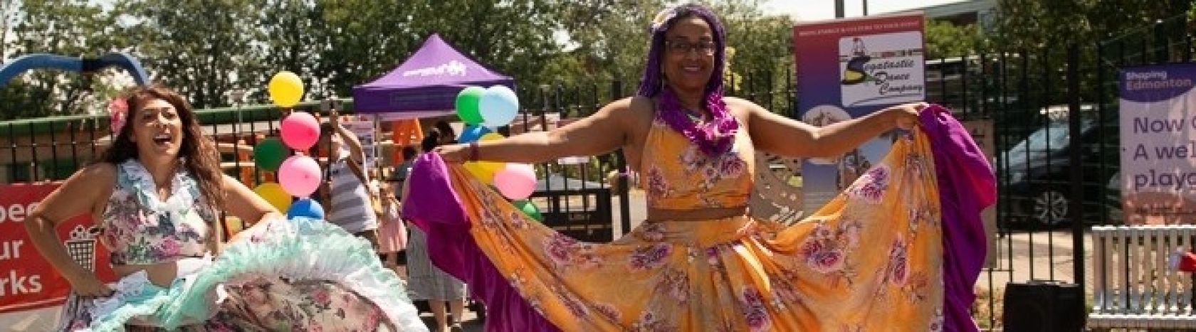 Dancers performing outside Florence Hayes Rec, wearing long colourful folk dresses