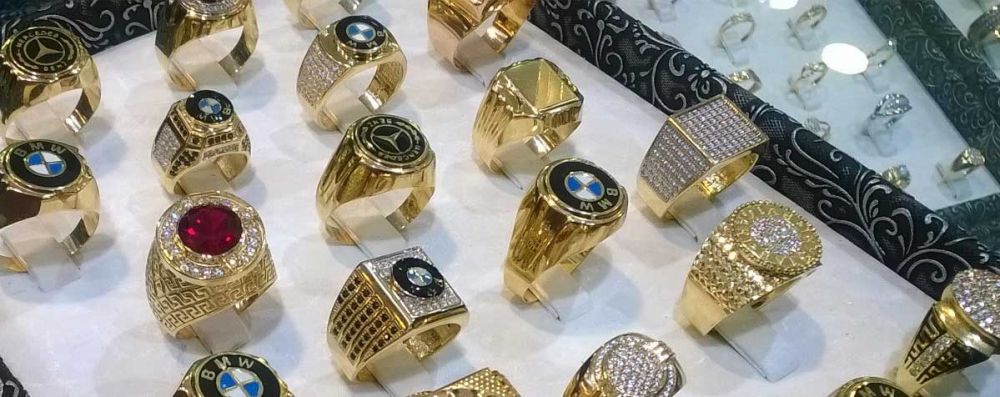 A tray of counterfeit rings with symbols such as BMW and Mercedes