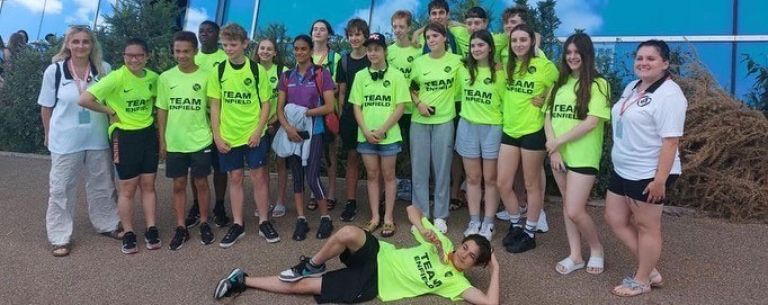 Enfield swimming team outside the aquatic centre wearing bright yellow t-shirts with the words Team Enfield