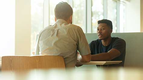 Two people talking over a table