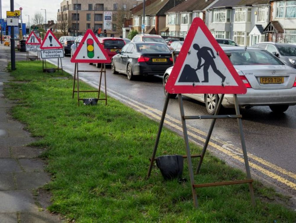 Lanes of traffic flanked by road works signage