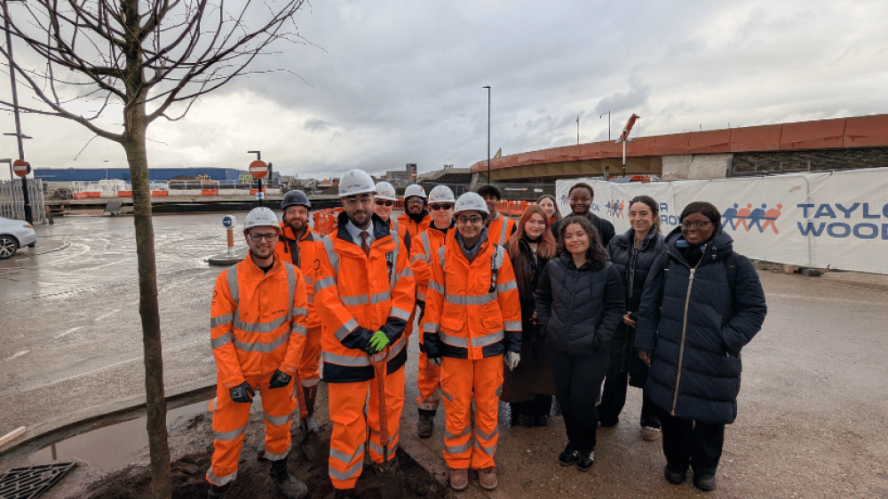 The Leader of The Council, Cllr Ergin Erbil, poses by the 1,000th Tree planted at the Strategic Infrastructure Works in Meridian Water