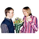 Man holding a bunch of flowers standing next to a woman