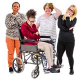 3 women standing next to a woman in a wheelchair